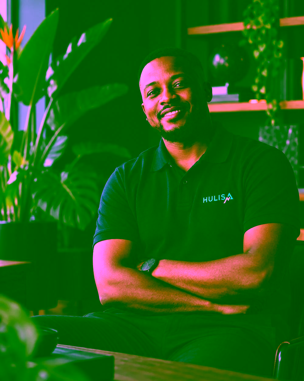 Illustrative portrait of a digital strategist wearing a Hulisa polo in a plant-filled studio